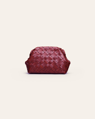 Burgundy woven leather clutch on a light beige background