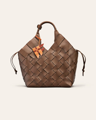 Cala Jade Misu large. A brown woven shoulder bag with a leather bag charm shaped as a fish on a light beige background