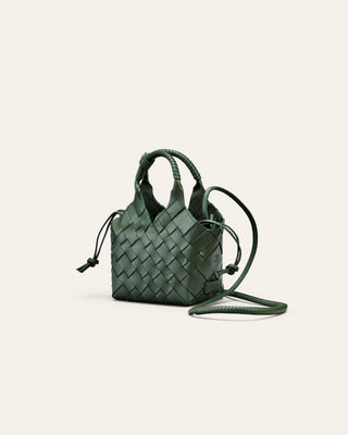 Cala Jade Misu Mini Green woven handbag on a light beige background seen from the side