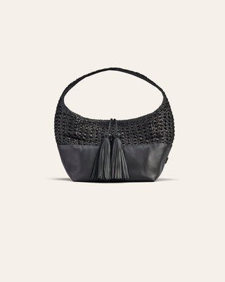Black woven handbag with leather tassels on a light beige background