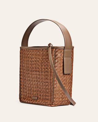 Dark beige woven shoulder bag with a matching strap on a beige background