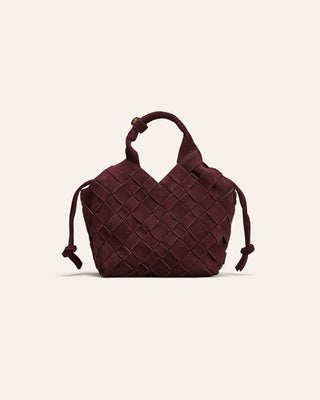 A burgundy nubucck woven leather bag on a beige background