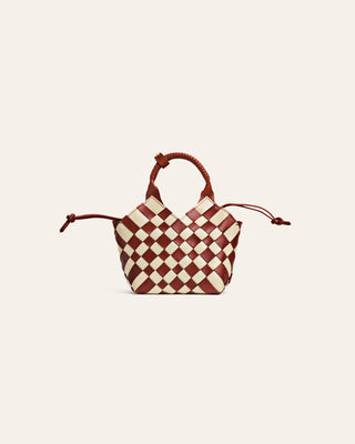 Checkered black and brown handbag with brown handles on a beige background
