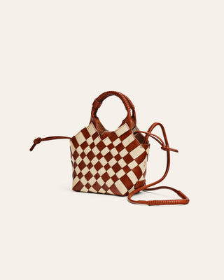 Checkered brown and white handbag with brown and white pattern on a beige background