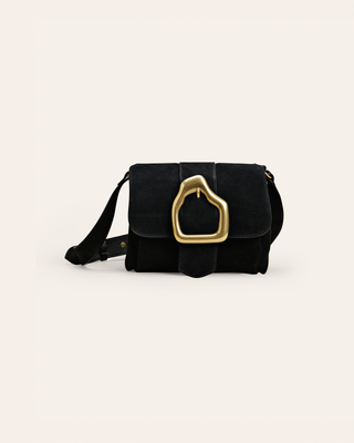 Black suede leather shoulder bag with a gold buckle on beige background