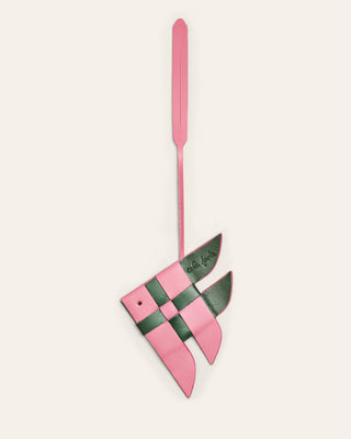 Pink and green leather charm with a strap on a white background