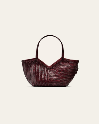 A burgundy woven shoulder bag on a beige background