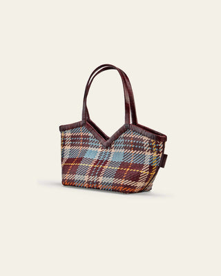 Patterned handbag with brown handle on a light beige background