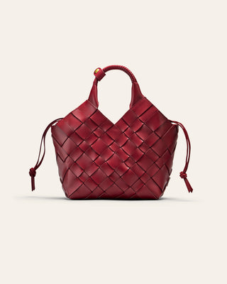 A red woven leather bag on a beige background