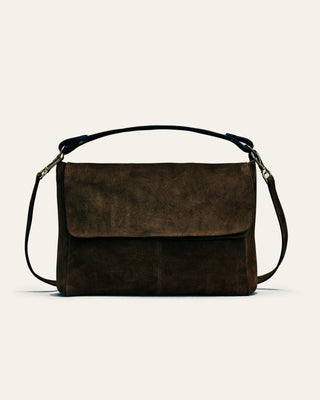 A dark brown suede shoulder bag on a beige background