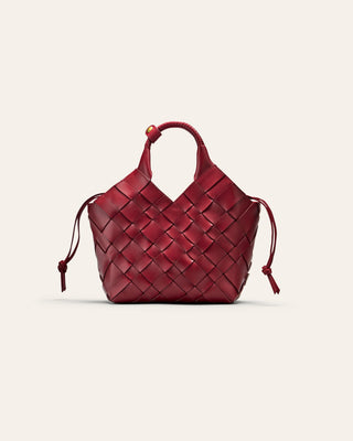 A red woven leather bag on a beige background