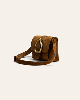 Brown leather bag with gold buckle on a light beige background