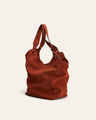 Red suede leather handbag on a beige background