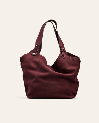 Burgundy suede handbag on a light beige background