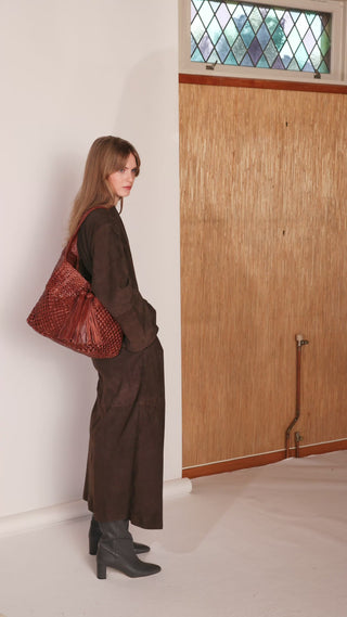 A video of a woman with a brown shoulder bag